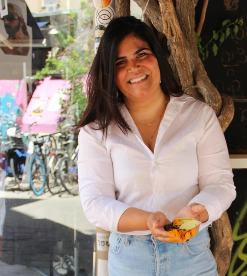 ענבל מחזיקה צמחים ותבלינים בשוק לוינסקי